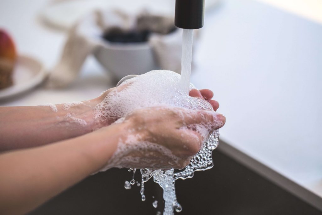 Mężczyzna myjący ręce w umywalce
